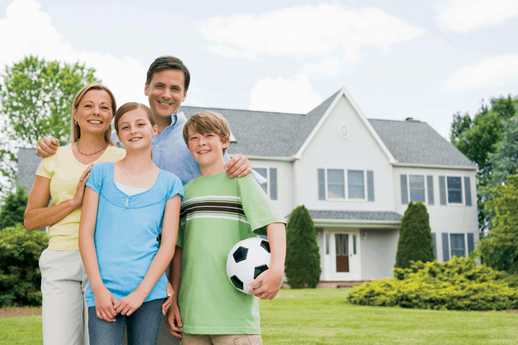 smiling family by house in front yard